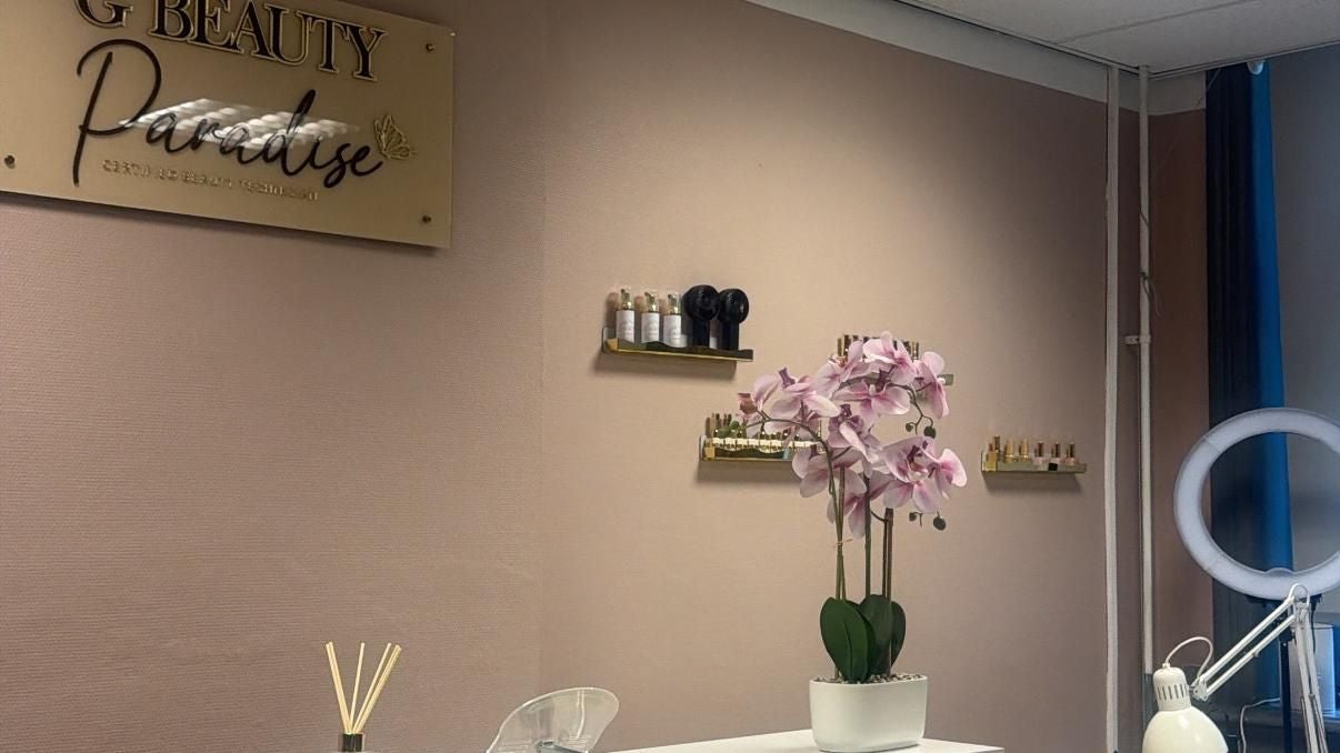 De studio: roze wanden, het gouden bord met G Beauty Paradise, een orchidee en de ringlamp