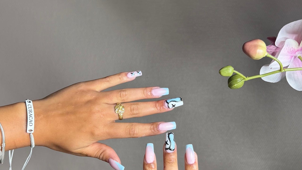 Hand met nail art in lichtblauw en zwart op lange nagels